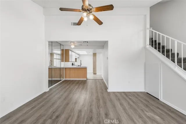a view of a kitchen with wooden floor and a ceiling fan