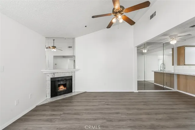 a view of empty room with wooden floor and ceiling fan