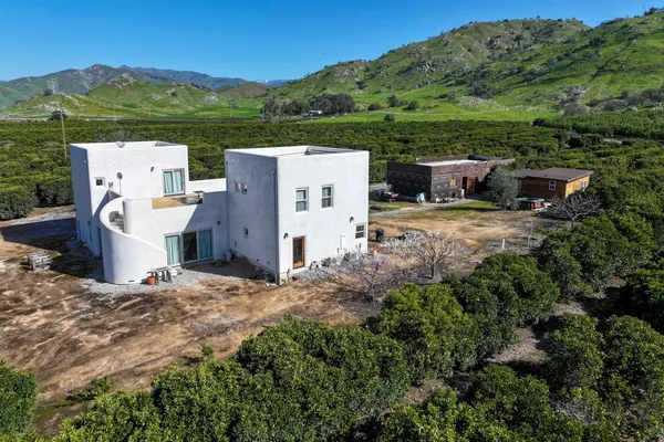 an aerial view of a house with pool big yard and large tree