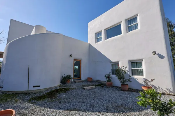 a backyard of a house with potted plants and couches