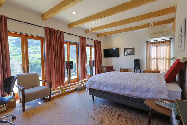 a bedroom with a bed couch and a window