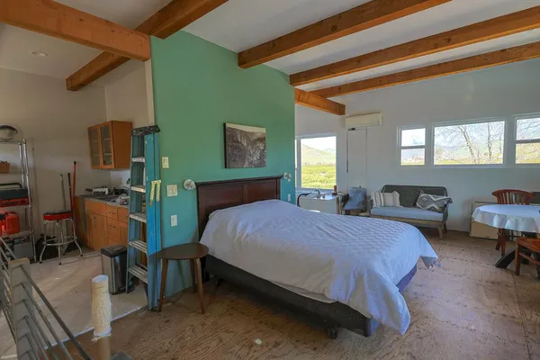 a spacious bedroom with a bed a table and chair