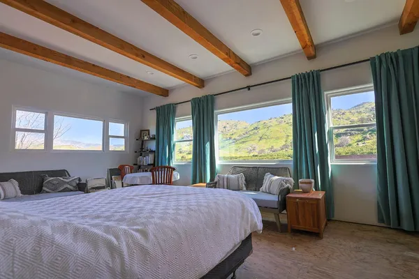 a bed sitting in a spacious bedroom next to a large window