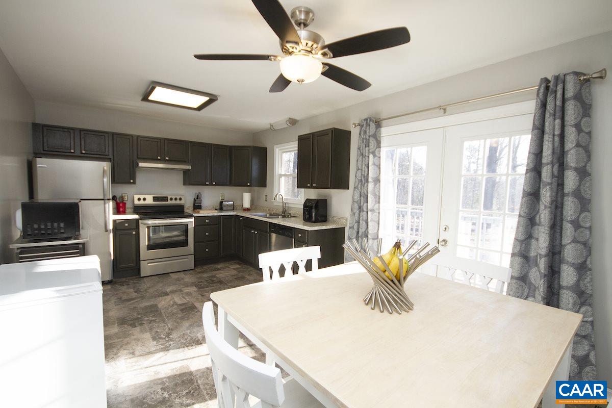 116 Tulip Road Ruckersville, VA 22968 - Photo 7 of 19 a kitchen with stainless steel appliances kitchen island granite countertop a sink a stove and a microwave