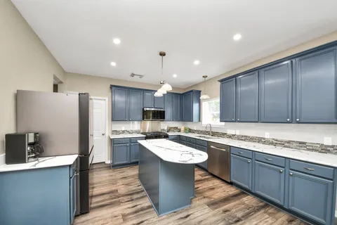 a kitchen with a sink a refrigerator and cabinets
