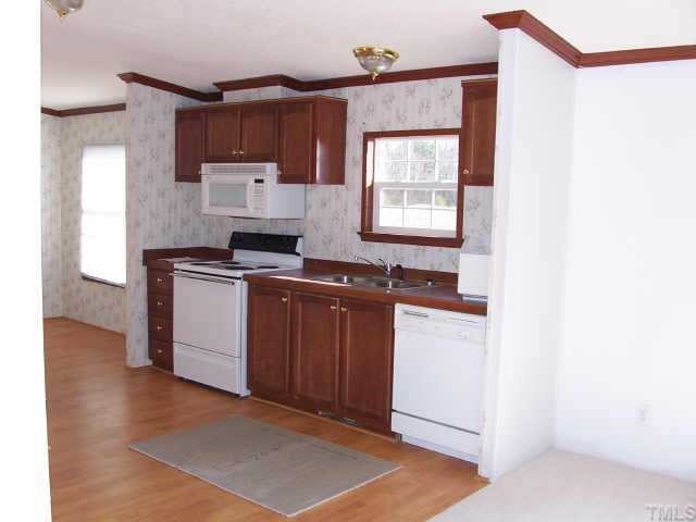 4549 Brantley Road Zebulon, NC 27597 - Photo 5 of 7 a kitchen with a stove a sink and a microwave