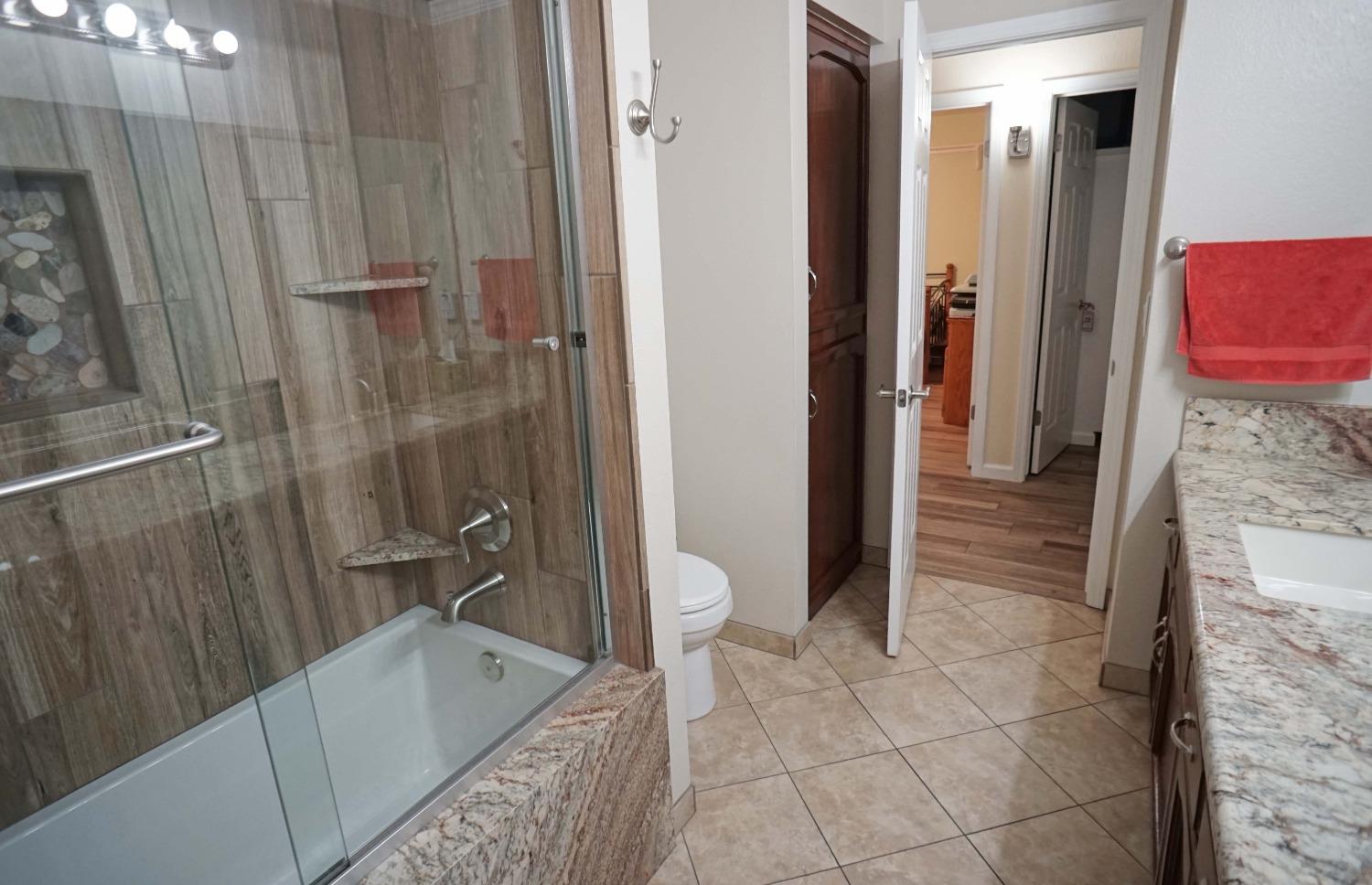 2197 Polson Avenue Clovis, CA 93611 - Photo 23 of 42 a bathroom with a granite countertop sink a toilet and shower