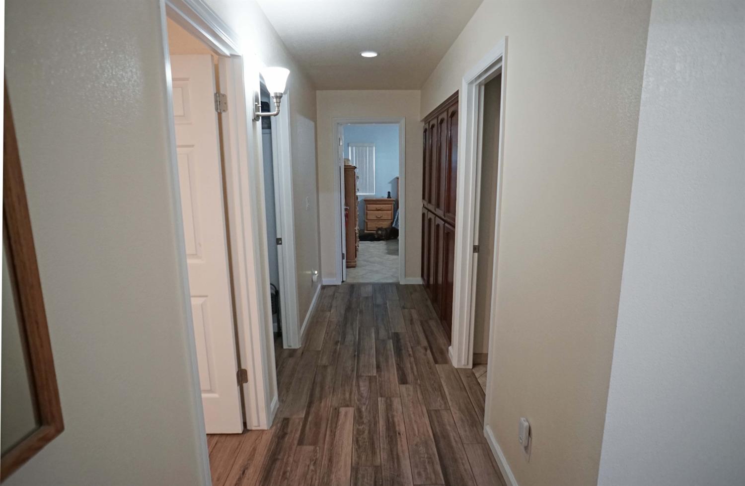 2197 Polson Avenue Clovis, CA 93611 - Photo 24 of 42 a view of a hallway with wooden floor and a bathroom