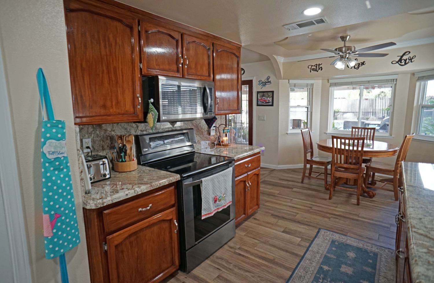 2197 Polson Avenue Clovis, CA 93611 - Photo 9 of 42 a kitchen with stainless steel appliances granite countertop wooden cabinets a stove top oven a sink and dishwasher