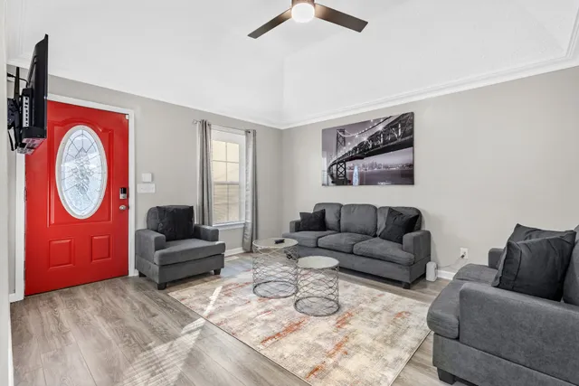 a living room with furniture a clock and a window