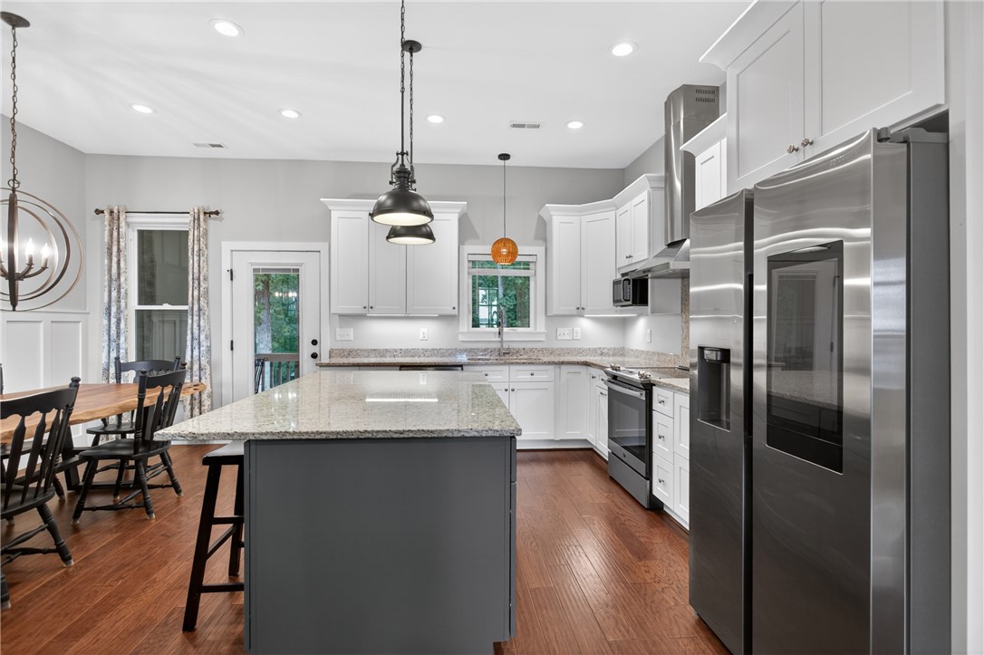 2024 Retreat Pointe Road West Union, SC 29696 - Photo 15 of 43 A well-appointed kitchen showcasing a spacious island, rich engineered hardwood flooring, and abundant cabinetry.