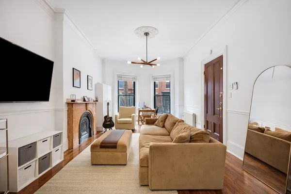a living room with furniture a flat screen tv and a fireplace