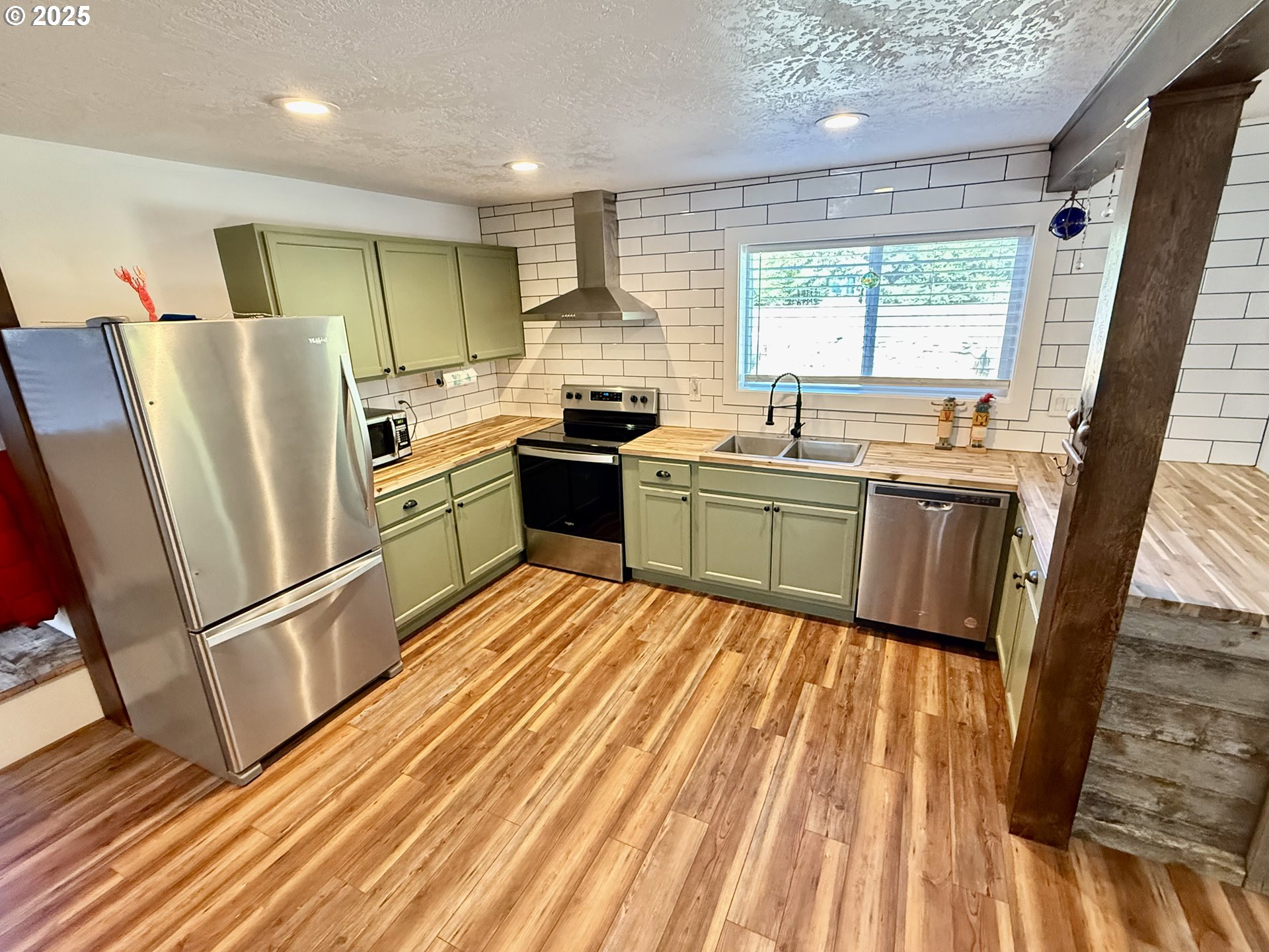 35349 Blitz Lane Blodgett, OR 97326 - Photo 13 of 47 a kitchen with stainless steel appliances granite countertop a refrigerator a sink dishwasher a stove and white countertops with wooden floor