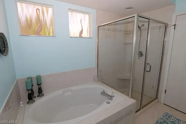 a white bath tub sitting next to a shower