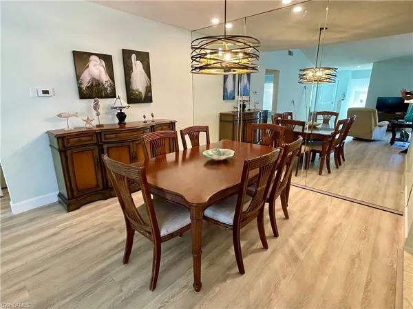a view of a dining room with furniture chandelier and wooden floor