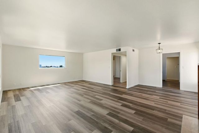 a view of a livingroom with wooden floor and a ceiling fan