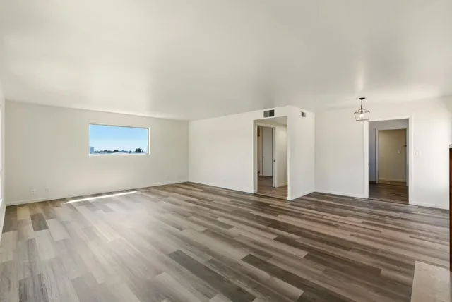 a view of a livingroom with wooden floor and a ceiling fan