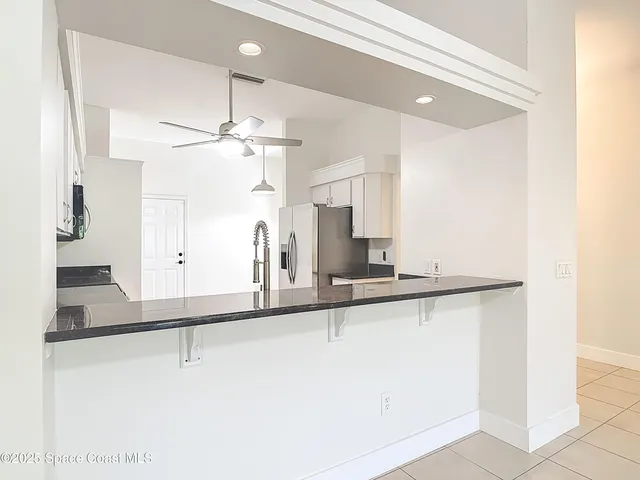 a view of a kitchen with refrigerator and window