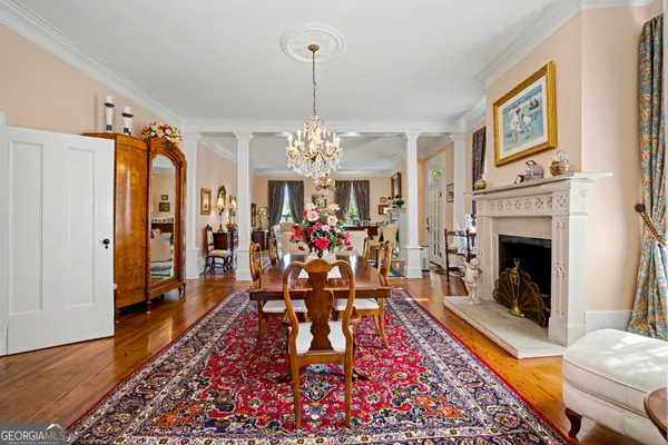 a view of a dining room with furniture a chandelier and wooden floor