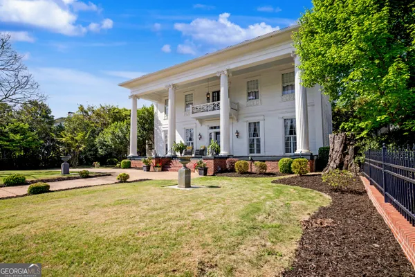 a view of swimming pool with lawn chairs and plants
