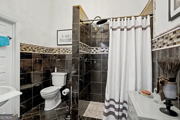 a bathroom with a granite countertop sink mirror and shower