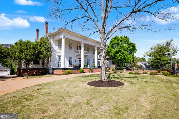 a front view of a house with a garden and plants