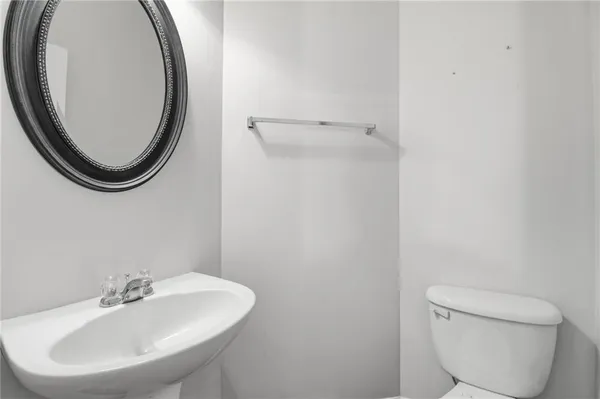 a bathroom with a toilet a sink and a mirror