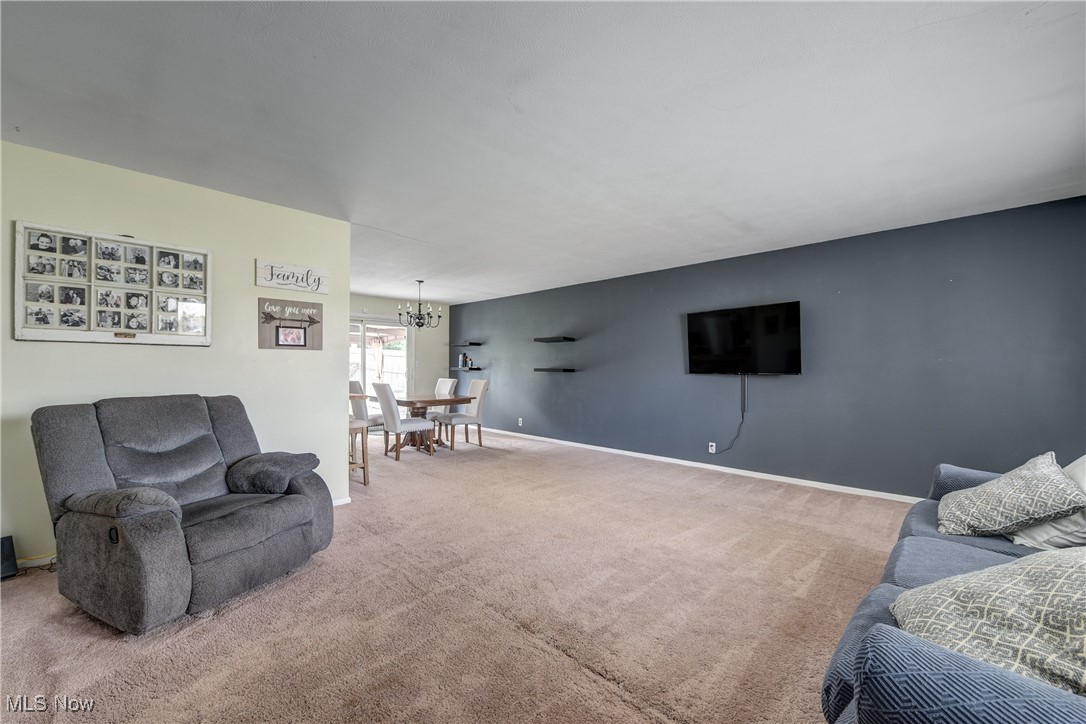 13765 Newton Road Cleveland, OH 44130 - Photo 5 of 42 Carpeted living area with a chandelier and baseboards