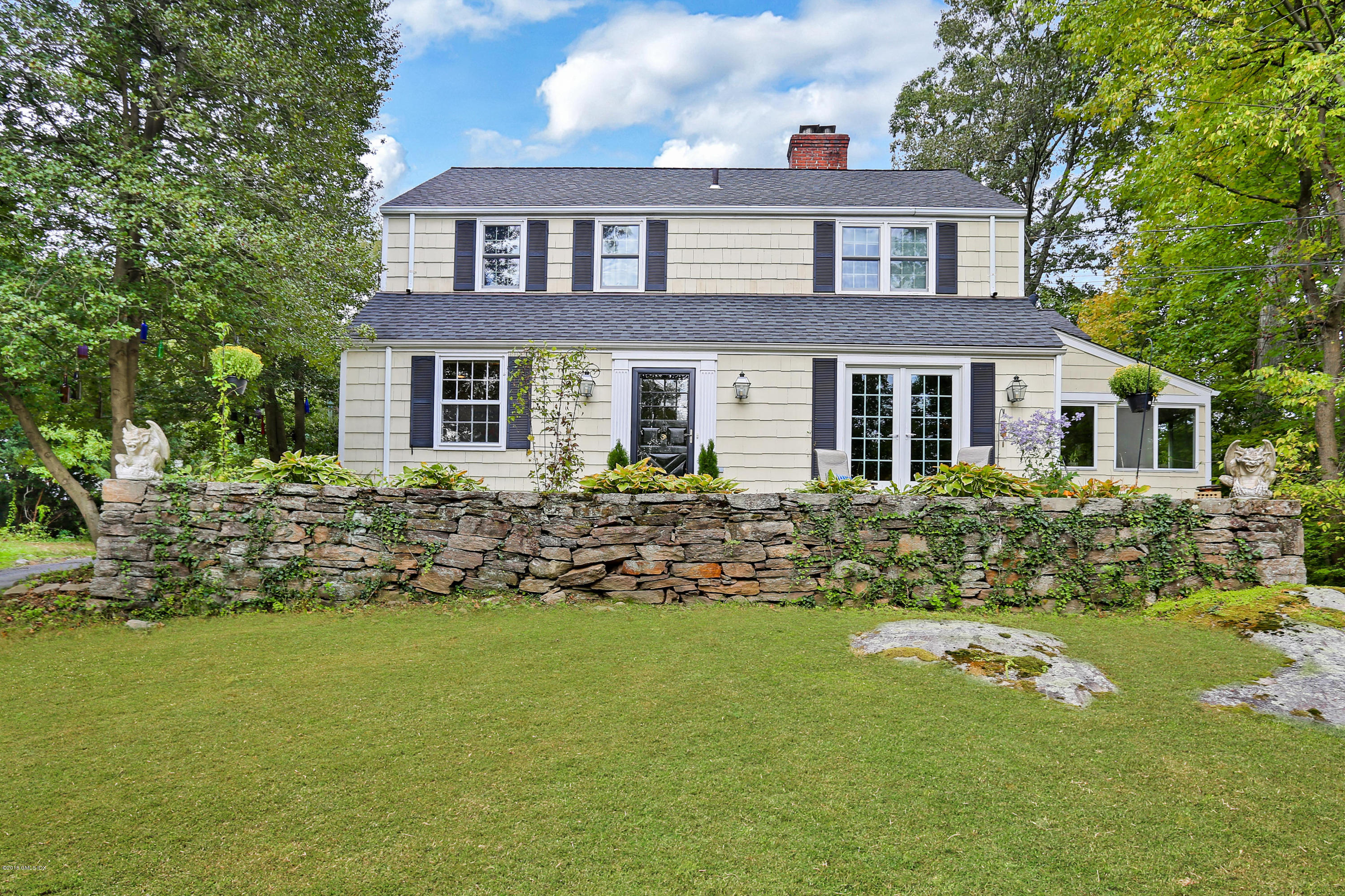 125 Hendrie Avenue Riverside, CT 06878 - Photo 1 of 24 a front view of a house with a garden