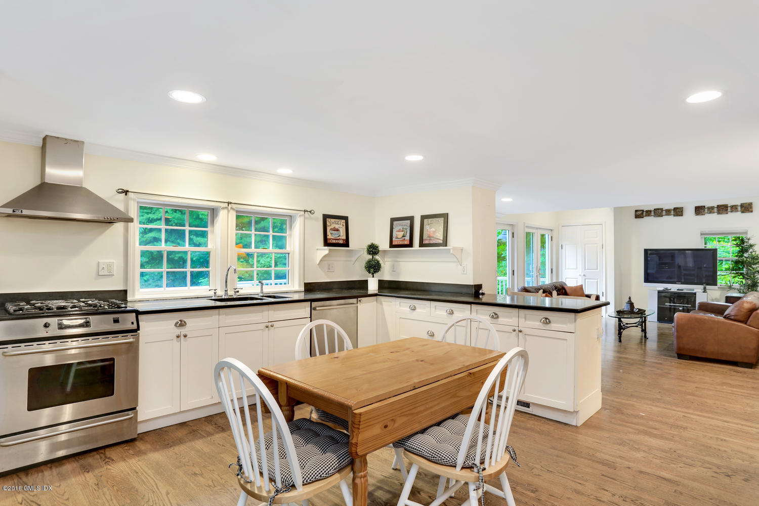 125 Hendrie Avenue Riverside, CT 06878 - Photo 8 of 24 a kitchen with stainless steel appliances granite countertop a stove top oven a sink dishwasher and white cabinets with wooden floor