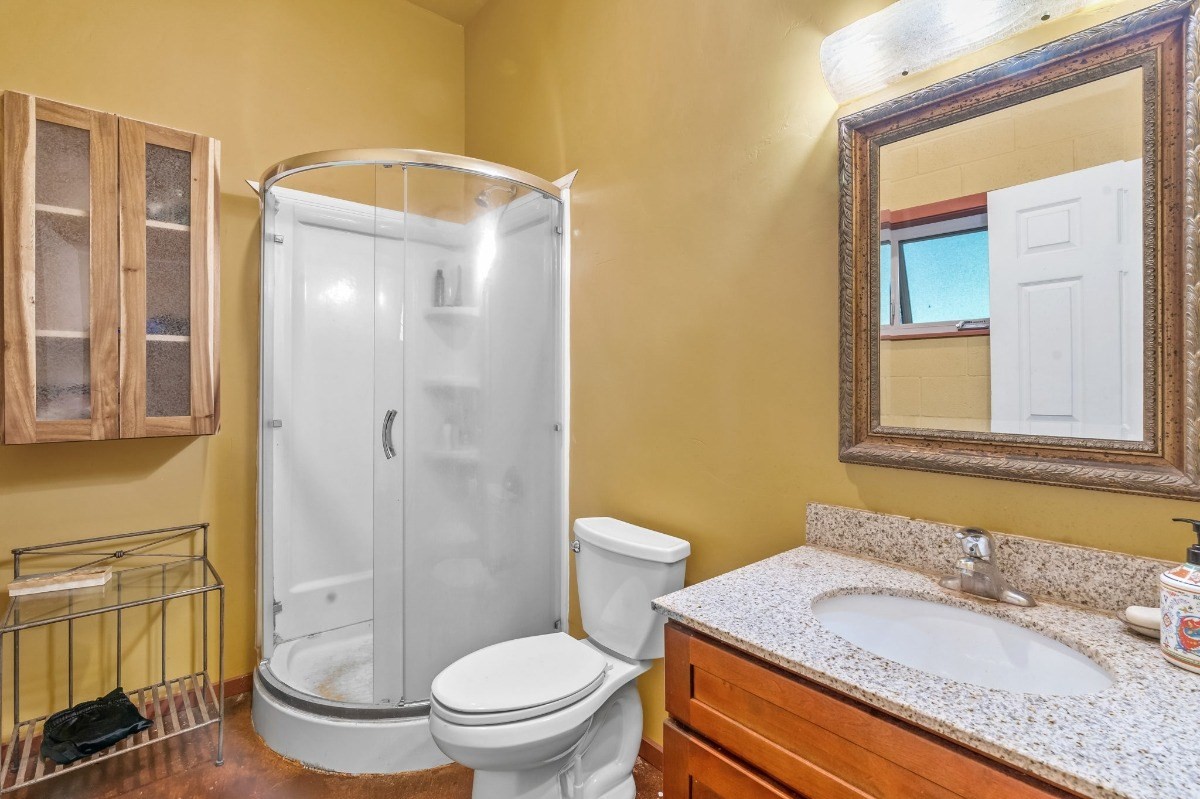 5011 Awawa Road Kalaheo, HI 96741 - Photo 27 of 30 a bathroom with a granite countertop toilet a sink and a mirror