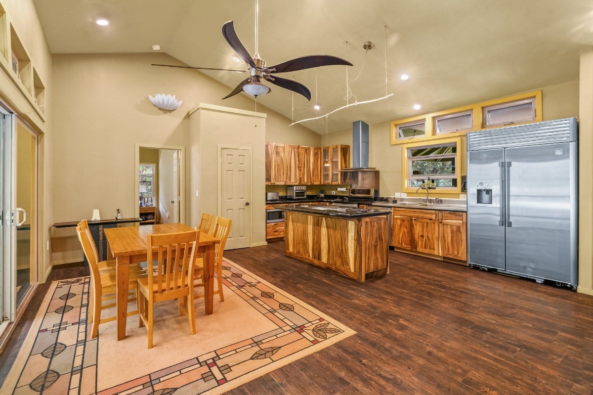 5011 Awawa Road Kalaheo, HI 96741 - Photo 5 of 30 a kitchen with stainless steel appliances kitchen island granite countertop a table chairs and a refrigerator