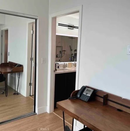 a view of a hallway with furniture and wooden floor