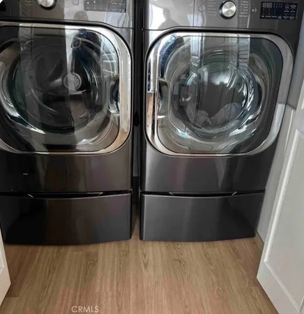 a utility room with wooden floor and toilet