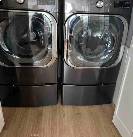 a utility room with wooden floor and toilet