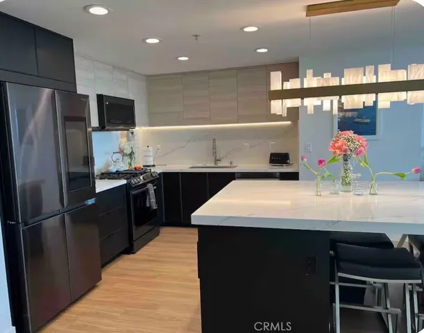 a kitchen with kitchen island stainless steel appliances a sink stove and refrigerator