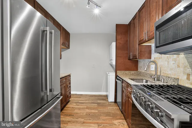 a kitchen with granite countertop a stove and a refrigerator