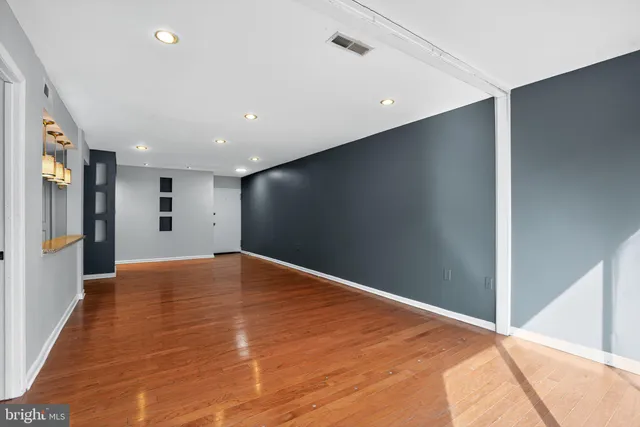 a view of an empty room with wooden floor