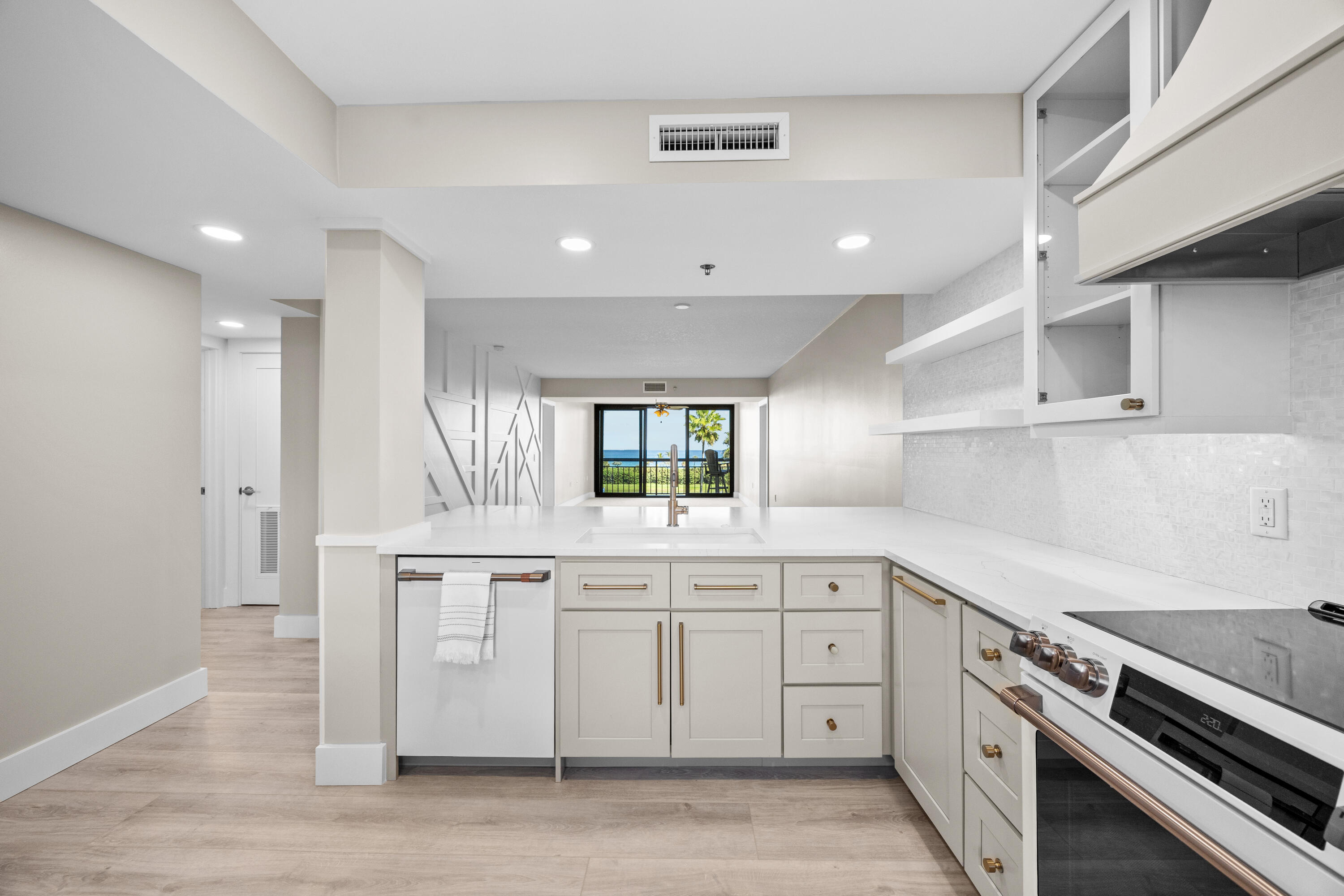 401 South Seas Drive, Unit 505 Jupiter, FL 33477 - Photo 14 of 39 a kitchen with white cabinets stainless steel appliances and sink