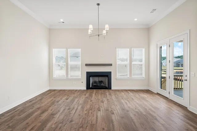 wooden floor fireplace and windows in an empty room