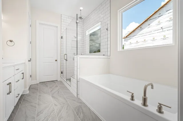 a bathroom with a tub shower and sink