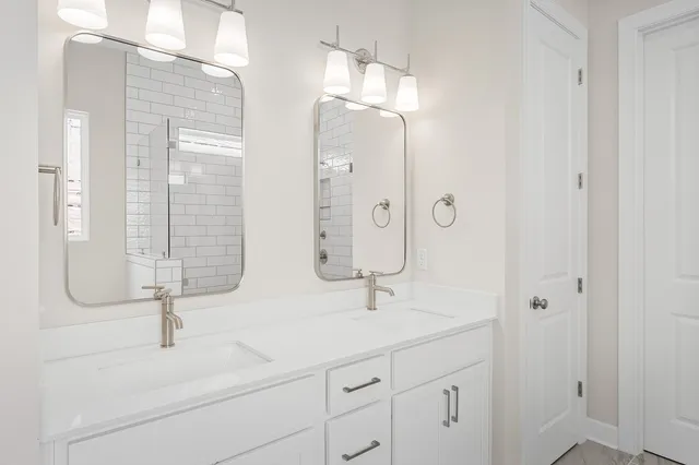 a bathroom with double vanity sinks and a mirror