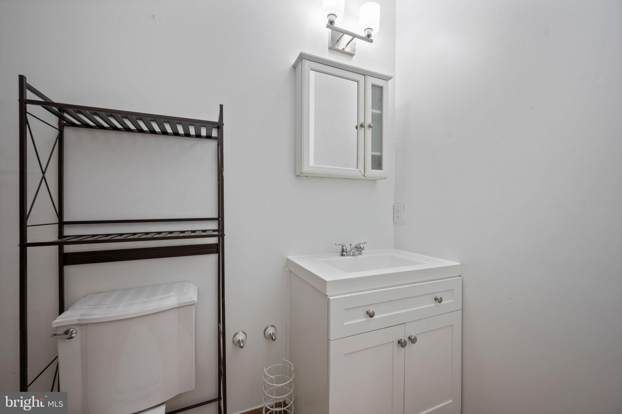 2422 Madison Avenue, Unit 1 Baltimore, MD 21217 - Photo 11 of 34 a bathroom with a toilet a sink and mirror