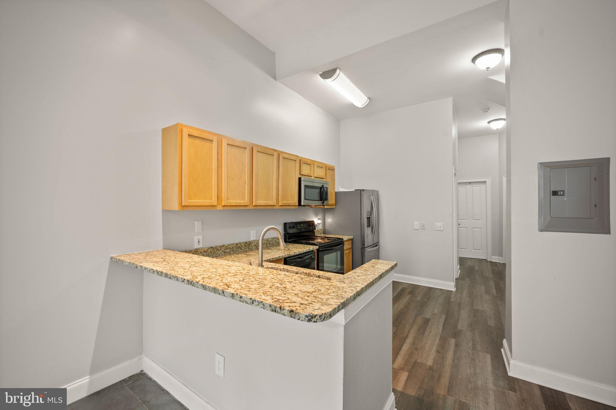 2422 Madison Avenue, Unit 1 Baltimore, MD 21217 - Photo 14 of 34 a kitchen with granite countertop cabinets a sink and a wooden floor