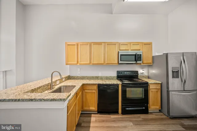 a kitchen with stainless steel appliances a stove sink microwave and refrigerator
