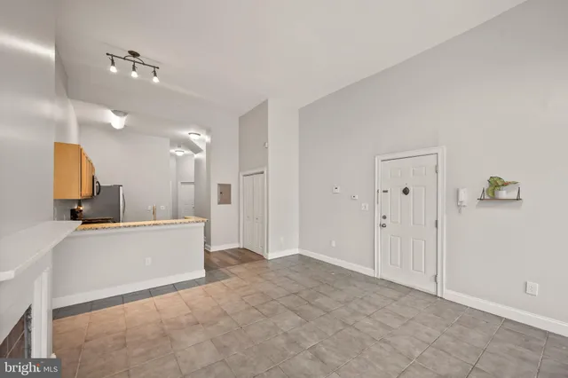 a view of kitchen with granite countertop cabinets and refrigerator