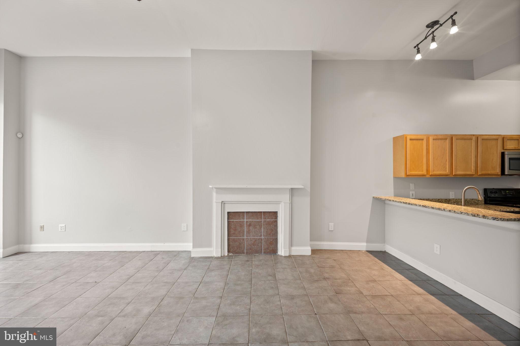 2422 Madison Avenue, Unit 1 Baltimore, MD 21217 - Photo 20 of 34 a view of a kitchen with a sink a dishwasher cabinets and a fireplace