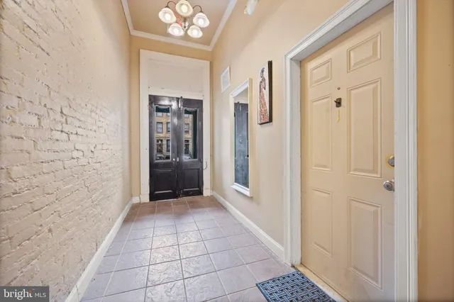an empty room with chandelier fan and windows