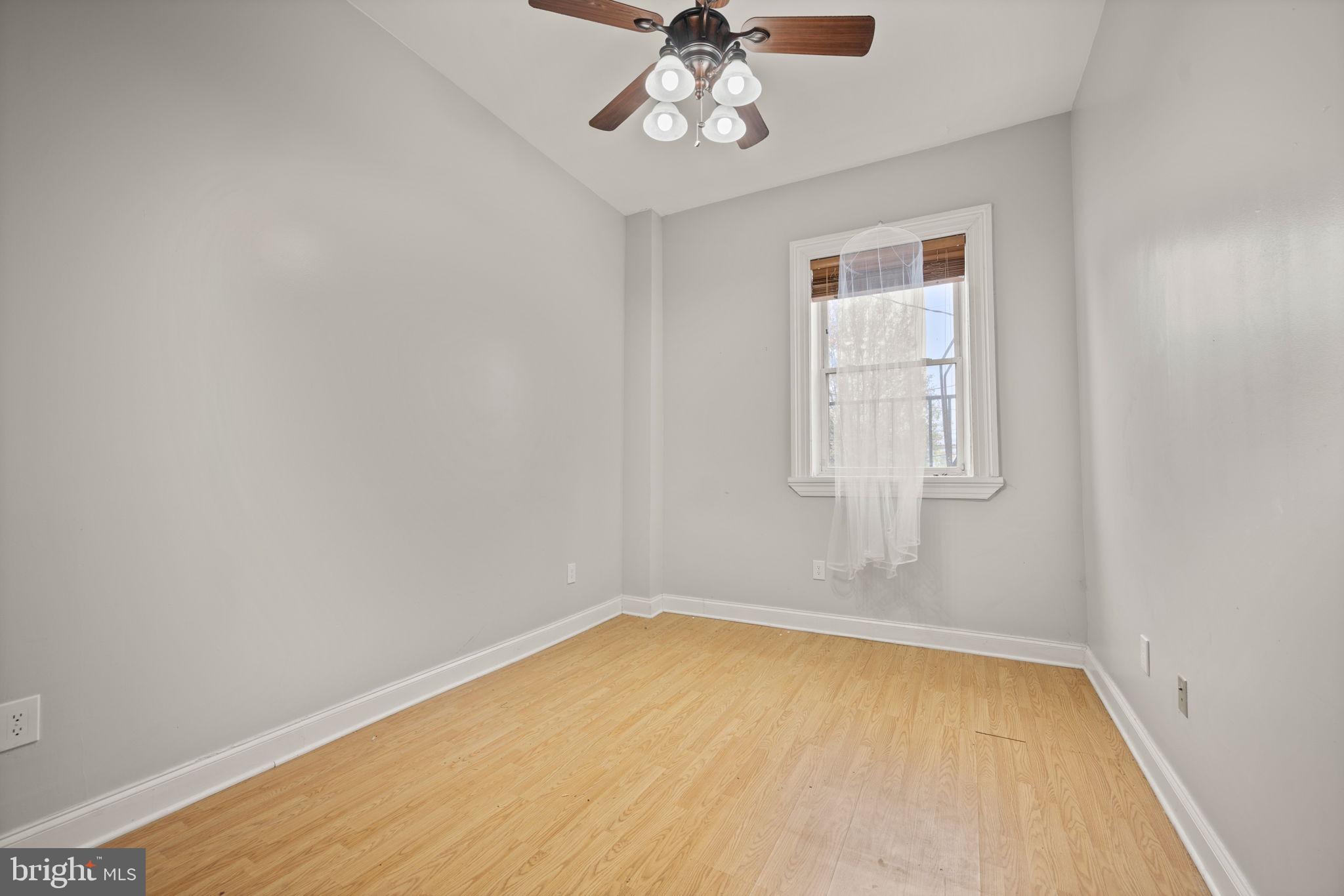 2422 Madison Avenue, Unit 1 Baltimore, MD 21217 - Photo 30 of 34 an empty room with chandelier fan and windows