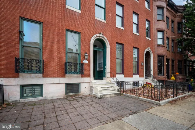 a view of a brick building with a bench in front of building